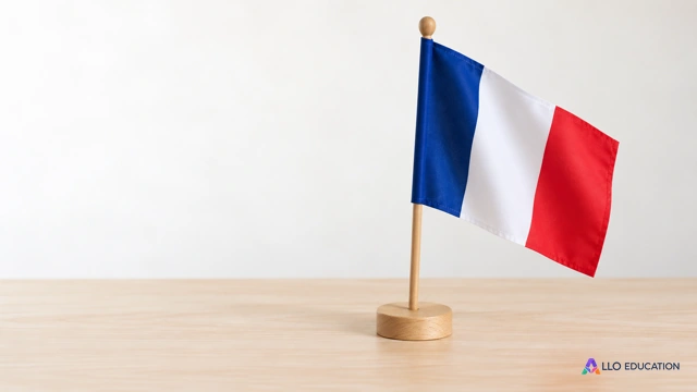 Un drapeau français bleu, blanc et rouge sur une hampe et un socle en bois.